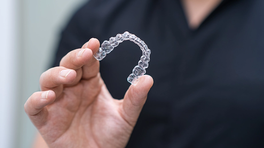 Close-up shot of orthodontist holding up retainers